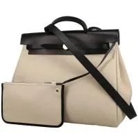 Сумка Hermès Herbag, которую можно носить на плече или в руке, из бежевой парусины и черной кожи.